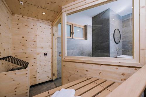 a wooden bathroom with a large window and a sink at Moidi's Chalet Spieljoch in Fügenberg