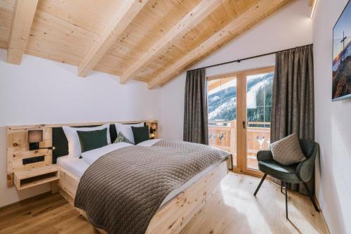 a bedroom with a bed and a large window at Moidi's Chalet Spieljoch in Fügenberg