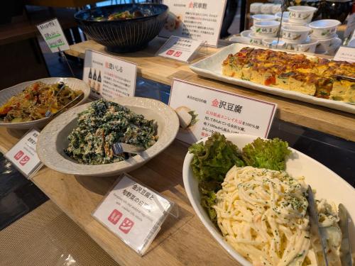 Un buffet de diferentes tipos de comida en una mesa. en APA Hotel Kanazawa Chuo, en Kanazawa
