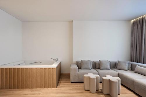 a living room with a couch and a bath tub at Nur City Suites in Athens