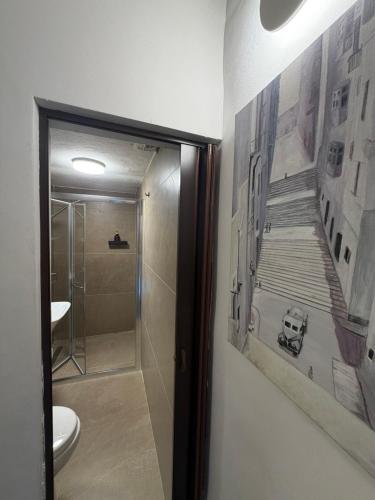 a bathroom with a toilet and a painting of a staircase at 3 St Anne's Street in Valletta
