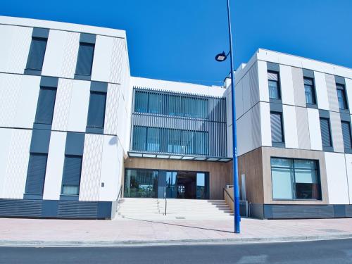 a building on a city street with a blue pole at Canvas Sevilla Lago in Seville