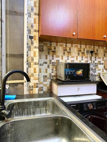 una cocina con fregadero y microondas en Fola Homes, en Suru Lere