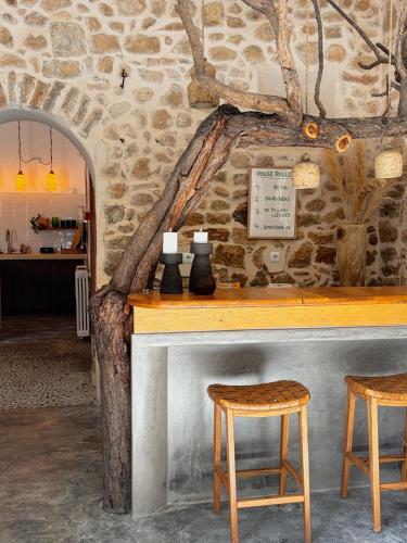 a bar with two stools and a stone wall at Alphea1570 in Lloseta
