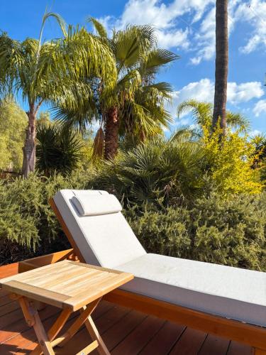 a chair and a table on a deck with palm trees at Alphea1570 in Lloseta