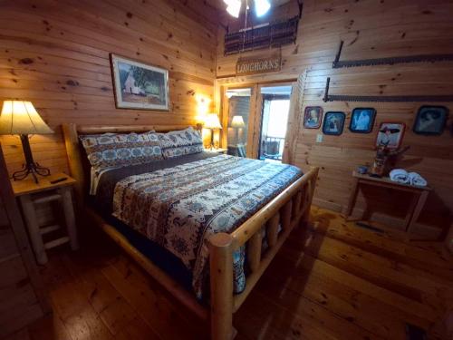 um quarto com uma cama num chalé de madeira em The Reservation- On the River em Cove Creek Cascades