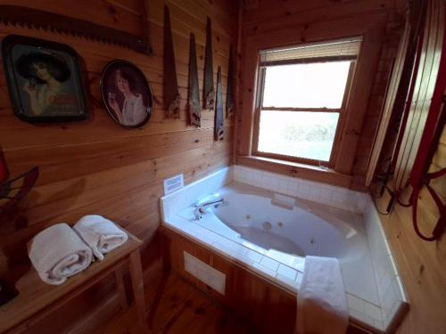uma casa de banho com banheira num chalé de madeira em The Reservation- On the River em Cove Creek Cascades