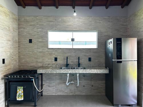 a kitchen with a sink and a refrigerator at Casa da Sil in Arraial d'Ajuda
