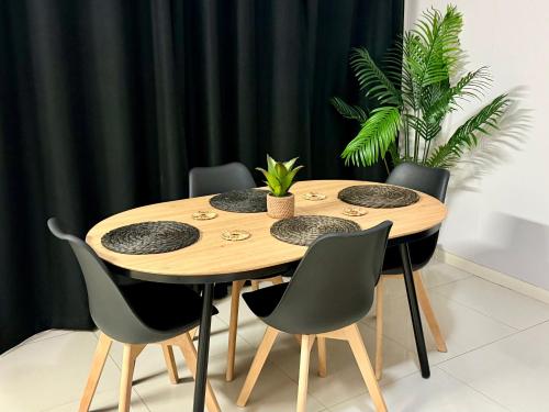 a dining room table with chairs and a table with plants at uMhlanga Condo - Location, Location, Location in Durban