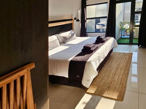 a bedroom with a large bed with towels on it at uMhlanga Condo - Location, Location, Location in Durban