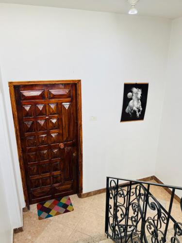 a room with a wooden door and a picture on a wall at Tara Apartments in Luxor