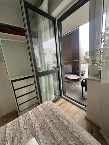 a bedroom with a large glass door leading to a patio at SPV Rentals Pileckiego 59 lokal 258 free Parking Ursynów in Warsaw
