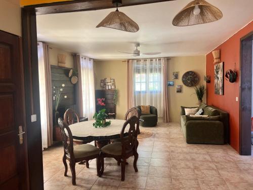 a living room with a table and chairs at Vi la dous Kreyol in Sainte-Rose