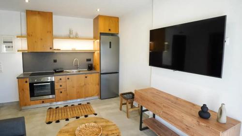 cocina con TV de pantalla plana grande en la pared en One Lemnos Apartments, en Limnos