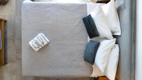 una mesa con tres almohadas encima en One Lemnos Apartments, en Limnos