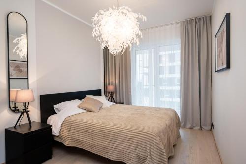 a bedroom with a large bed and a chandelier at Siili Riverview Stay in Tartu