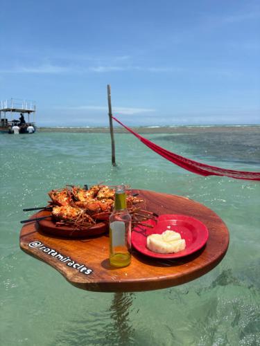 um prato de comida sobre uma mesa na água em Vilarejo dos Milagres em São Miguel dos Milagres