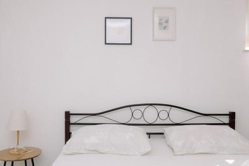 a white bedroom with a bed with two white pillows at Large and charming apartment near beach with big & sunny terrace in Sumartin