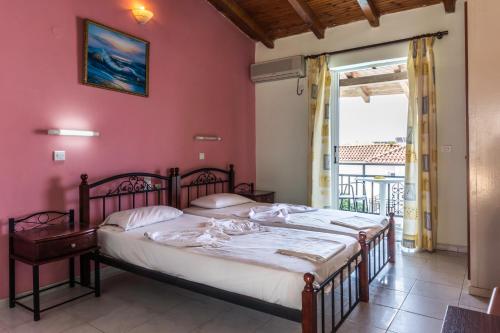 a bedroom with a bed and a large window at Vossos Hotel Apartments in Laganas