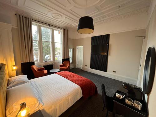a hotel room with a bed and a desk and chairs at The Graeme Hotel in Falkirk