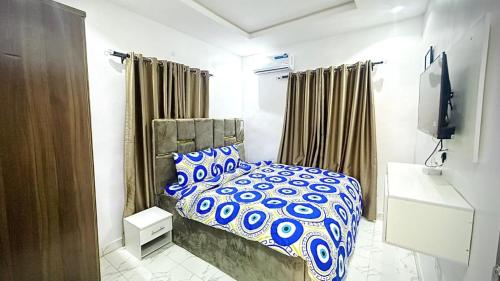 Un dormitorio con una cama con un edredón azul y blanco. en Kunbiz Apartments, en Murtala Muhammed International Airport