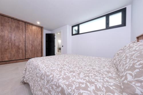 a bedroom with a large bed and a window at Luxury White House Apartment in Puerto Calero