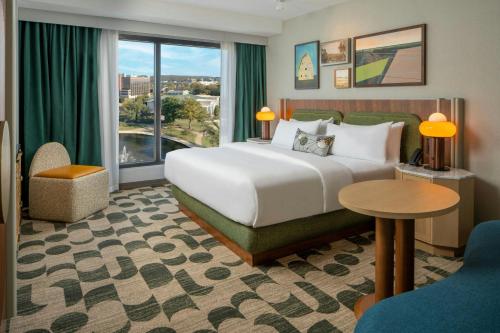 a hotel room with a bed and a large window at Trilogy Hotel Huntsville, Autograph Collection in Huntsville