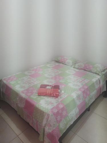een bed met een koffer bovenop bij Suite Airport in Campinas