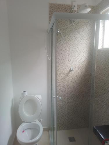 een badkamer met toilet en glazen douche bij Suite Airport in Campinas