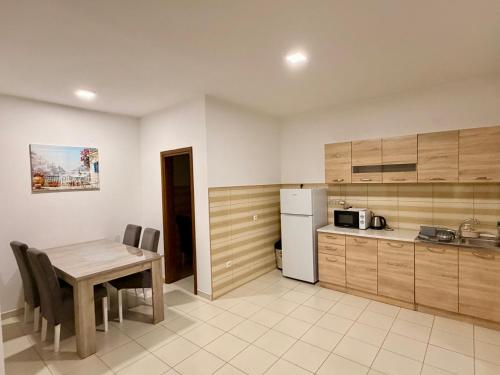 M apartment 3 في بار: مطبخ مع طاولة خشبية وطاولة وكراسي