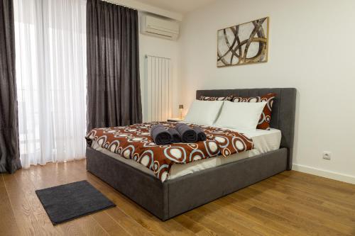 a bedroom with a large bed with brown and white sheets at Planet Residence - Harmony Lux & SPA in Niš
