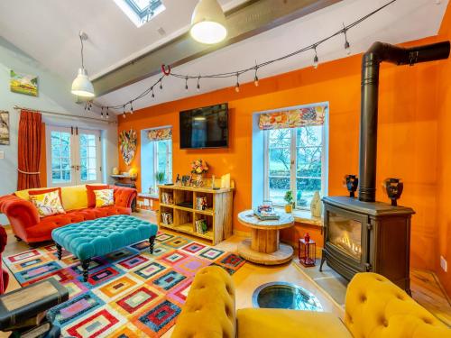 The Engine Room في مالهام: غرفة معيشة مع جدران برتقالية ومدفأة