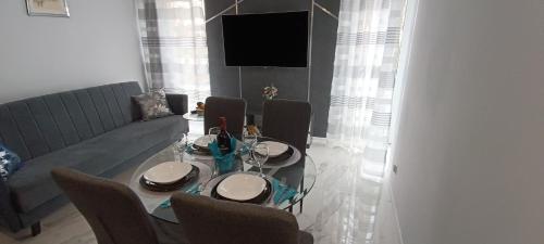a dining room with a table with chairs and a television at Good Place Kodowa in Skorka
