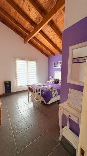 a room with two beds and a purple wall at Los Saucos in El Hoyo