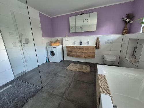 La salle de bains est pourvue d'une baignoire, d'un lavabo et d'un lave-linge. dans l'établissement Modern and idyllic apartment, à Jettingen-Scheppach