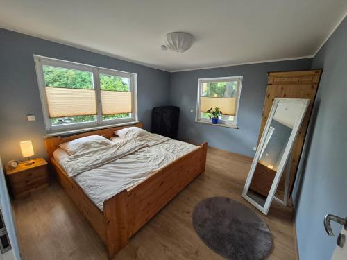 - une chambre avec un lit et un miroir dans l'établissement Modern and idyllic apartment, à Jettingen-Scheppach