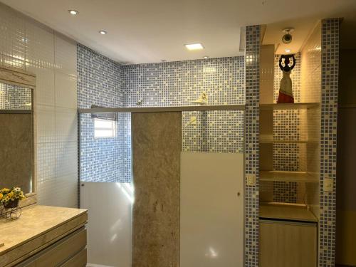 un bagno con doccia con piastrelle blu di ACONCHEGANTE Quarto a Rio Verde