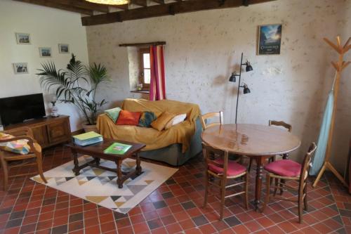 a living room with a couch and a table at À La Croisée Des Châteaux 3étoiles in Ouchamps
