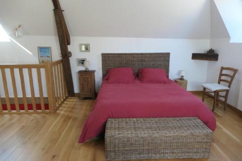 a bedroom with a large bed with a red bedspread at À La Croisée Des Châteaux 3étoiles in Ouchamps
