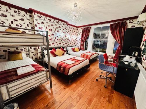 a bedroom with two bunk beds and a chair at Crompton Guest House in Hounslow