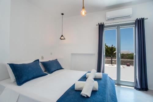 Bluebell Resort Villa SUNSET في كامبوس باروس: غرفة نوم بسرير ابيض مع مخدات زرقاء