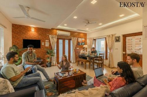 a group of people sitting in a living room at EKO STAY - Solace Villa I Charming Villa close to Candolim Beach in Candolim
