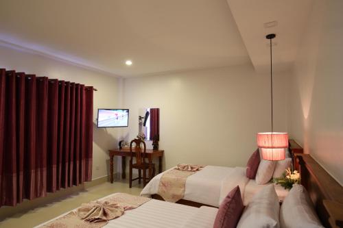 a hotel room with two beds and a tv at Holy Angkor Hotel in Siem Reap