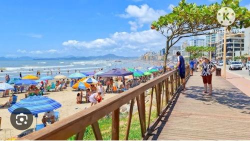 eine Menschenmenge an einem Strand mit Sonnenschirmen in der Unterkunft Residencial Baviera in Navegantes