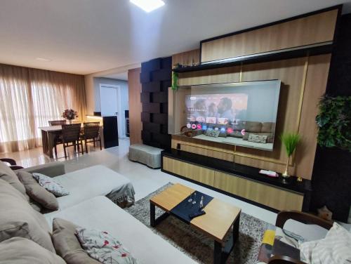 ein Wohnzimmer mit einem Flachbildfernseher an der Wand in der Unterkunft Residencial Baviera in Navegantes