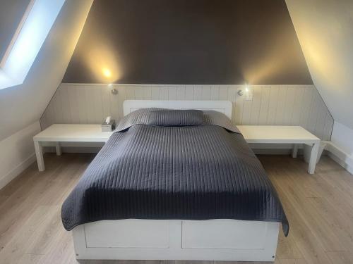 een slaapkamer met een groot bed en 2 banken bij La Vigne in Pelissous