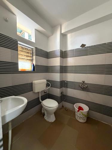 a bathroom with a toilet and a sink and a tub at Da Nest in Guwahati
