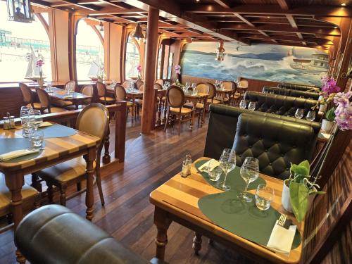 Hôtel La Riviera Victoria في إيفوار: مطعم به طاولات وكراسي في غرفة