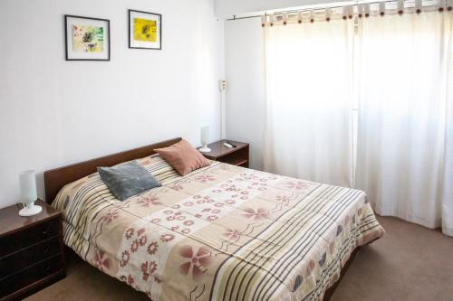 Amplio y cómodo - Excelente ubicación في ميندوزا: غرفة نوم بسرير وبطانية ونافذة