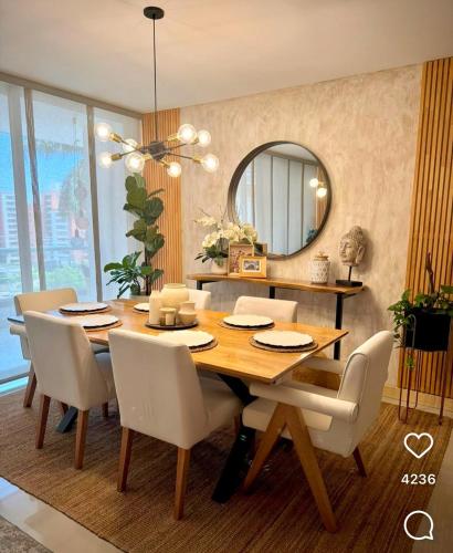 a dining room table with white chairs and a mirror at Recidencial in Mendoza